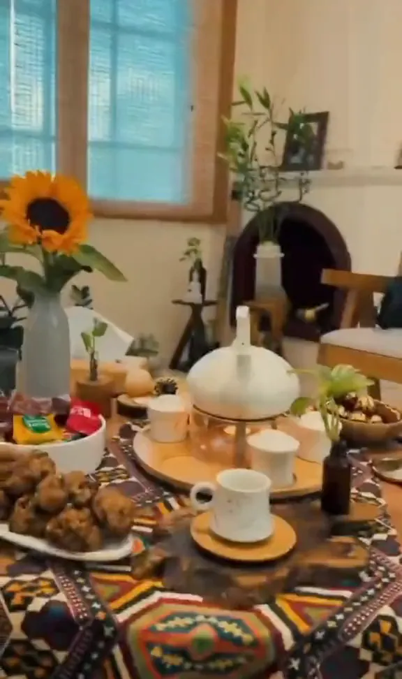 فضای سالن تی‌تی در گلسار رشت: میز چای، قفسهٔ روغن‌ها و تخت ماساژ